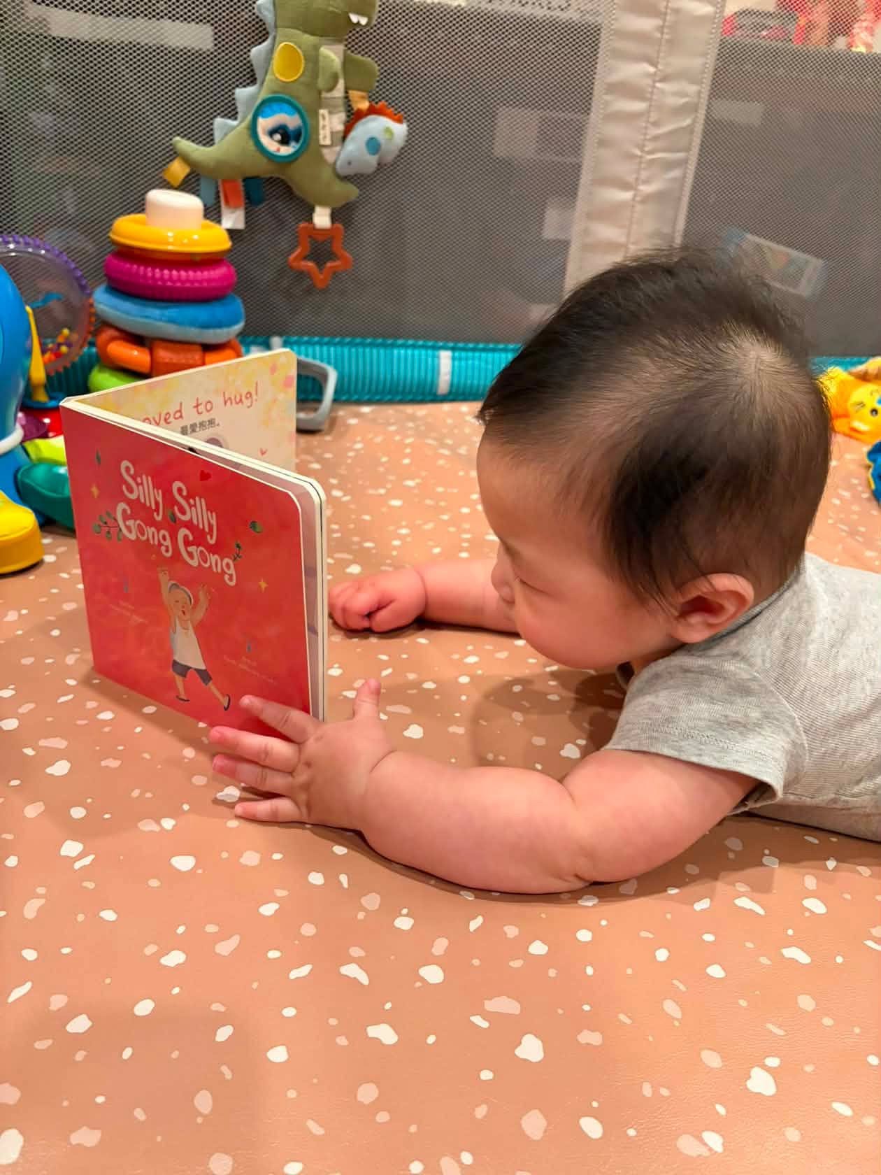 Một em bé thích thú xem sách Silly Silly Gong Gong